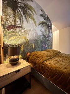 a bedroom with a bed and a wall with palm trees at La Maison de Pierrette in Les Baux-de-Provence