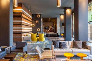 a lobby with couches and chairs and a staircase at Le Meridien Charlotte in Charlotte