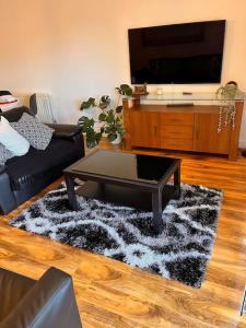 a living room with a coffee table and a flat screen tv at Luxurious river view apartment in London