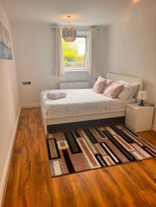 a bedroom with a bed with a window and a rug at Luxurious river view apartment in London
