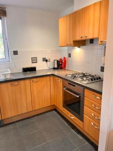 a kitchen with wooden cabinets and a stove top oven at Luxurious river view apartment in London