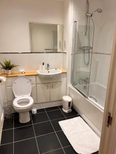 a bathroom with a toilet and a sink and a shower at Luxurious river view apartment in London