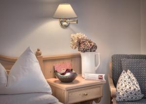 サン・カンディドにあるIl Tyrolのベッドルーム1室(ベッド1台、花瓶付きのテーブル付)