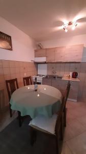 une cuisine avec une table et des chaises dans une pièce dans l'établissement Apartman Vule, à Pale 9 autres photos