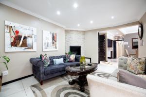 uma sala de estar com um sofá e uma mesa em URlyfstyle 5 bedrooms near OR Tambo international Airport em Kempton Park