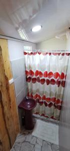 a bathroom with a red and white shower curtain at Mora's Place B&B in Monteverde Costa Rica