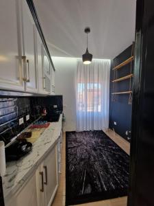 a kitchen with white cabinets and a black marble counter top at YourHome in Korçë +2 photos