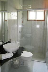 La salle de bains est pourvue de toilettes et d'une douche en verre. dans l'établissement Hotel I 7, à Parnamirim