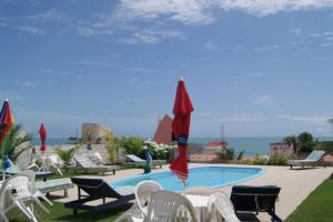 - une piscine avec des chaises et des parasols à côté de l'océan dans l'établissement Hotel I 7, à Parnamirim