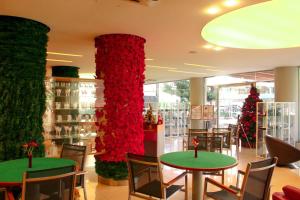 een kamer met twee tafels met rode bloemen en kerstbomen bij The Presidential Suit 2BR Apartment with Gym and Bar in Jounieh