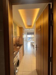 a hallway of a kitchen with a washer and dryer at Kevens Single Room with Gym and Bar in Jounieh