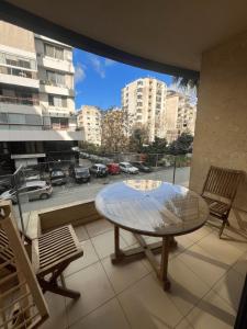 uma mesa numa varanda com vista para a cidade em Kevens Single Room with Gym and Bar em Jounieh