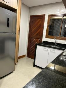 a kitchen with a refrigerator and a sink and a door at Apto 302 Edifício Manoel Teixeira in Arroio do Silva