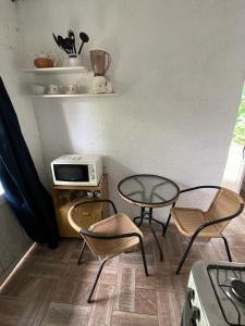 Zimmer mit 2 Stühlen, einem Tisch und einem Herd in der Unterkunft Casita sencilla en la Aguada in La Aguada