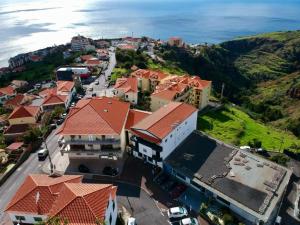 an aerial view of a town with houses and the ocean at Mountain View Star in Estreito da Calheta
