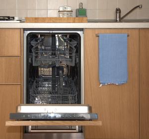 an open dishwasher with dishes in it in a kitchen at Casavimo in Vimodrone