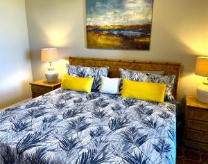 Un dormitorio con una cama azul y blanca con almohadas amarillas en Beach Villa 215, en Humacao