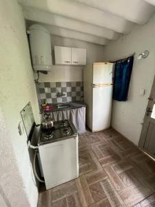 eine kleine Küche mit einem Herd und einem Kühlschrank in der Unterkunft Casita sencilla en la Aguada in La Aguada