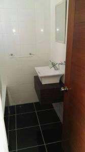 a bathroom with a white sink and a mirror at Hostal Casa Alegre in Valparaíso