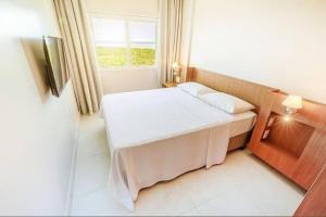 um pequeno quarto com uma cama e uma janela em Salinas Exclusive Resort em Salinópolis