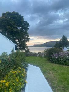 einen Weg hinunter zu einem Garten mit Blumen in der Unterkunft Curlew Cottage in Beltra