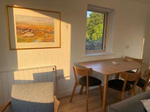 ein Raum mit einem Tisch und Stühlen und einem Fenster in der Unterkunft Curlew Cottage in Beltra