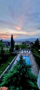 vistas a una piscina con sillas y a la puesta de sol en Villa Qeroli Saguramo en Saguramo
