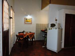 cocina con mesa y nevera blanca en Hostería Las Lomas en Cortaderas