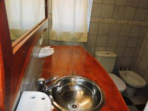 y baño con lavabo y aseo. en Hostería Las Lomas en Cortaderas