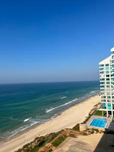 誒茲里亞的住宿－דירת נופש בהרצליה，享有海滩和大楼的空中景致