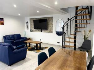 a living room with a blue couch and a table at Maison pour séjour in Mouzay