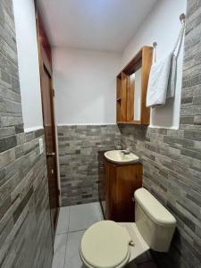 a bathroom with a toilet and a sink at El Encanto de Mimi in Puerto Ayora