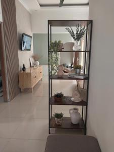 uma sala de estar com uma prateleira com plantas e vasos em Kenka Homestay 