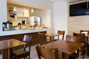 um restaurante com mesas e cadeiras e um balcão em PEDREIRA FLAT HOTEL em Pedreira