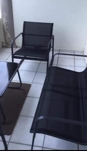 two black chairs sitting on a tiled floor at 15 uvongo square holiday home in Margate