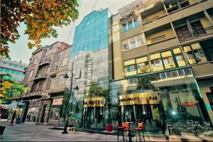 a city street with buildings and tables in front of a building at HOTEL ELSA in Skopje