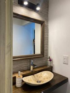 ein Bad mit einem Waschbecken und einem Spiegel in der Unterkunft Cabanas Soles del Este in Punta del Este