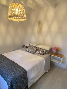 ein Schlafzimmer mit einem Bett mit Kissen und einer Lampe in der Unterkunft Cabanas Soles del Este in Punta del Este
