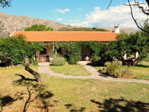 una casa con techo naranja en un patio en Hostería Las Lomas en Cortaderas