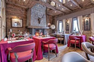 a restaurant with red tables and chairs and a fireplace at Chalet BRAGARD in Limone Piemonte