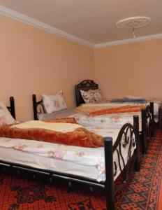 a group of three beds in a room at Hôtel Kasbah Telouet in Telouet