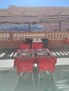 a table with two red chairs and a table with at Hôtel Kasbah Telouet in Telouet
