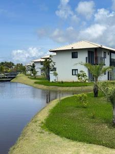 una casa junto a un río al lado de una casa en Vila do Lago Praia do Forte en Mata de Sao Joao