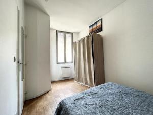a bedroom with a bed and a door to a window at L'appart d'Avignon in Avignon