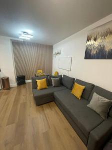 ein Wohnzimmer mit einem grauen Sofa und gelben Kissen in der Unterkunft BROADWAY SUITE - Newly refurbished stylish apartment with FREE PRIVATE PARKING - Great location in Birmingham