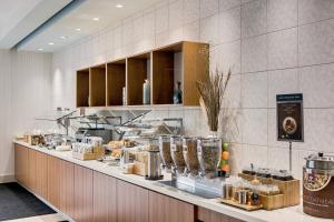 una cocina con una barra con comida. en SpringHill Suites by Marriott Houston The Woodlands, en The Woodlands