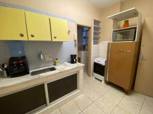 a kitchen with a sink and a refrigerator at Apartamento no coração de Petrópolis in Petrópolis