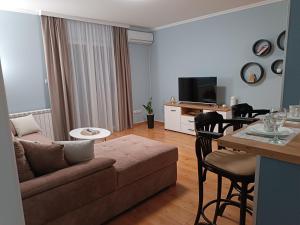 een woonkamer met een bank en een tafel bij Apartman Jela in Borča