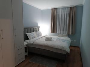 a small bedroom with a bed and a mirror at Apartman Jela in Borča