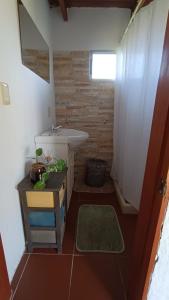 uma casa de banho com um lavatório, um WC e uma mesa em Adorable microcasa a 4km del centro de Maldonado y de playa mansa, en barrio muy tranquilo! em Maldonado